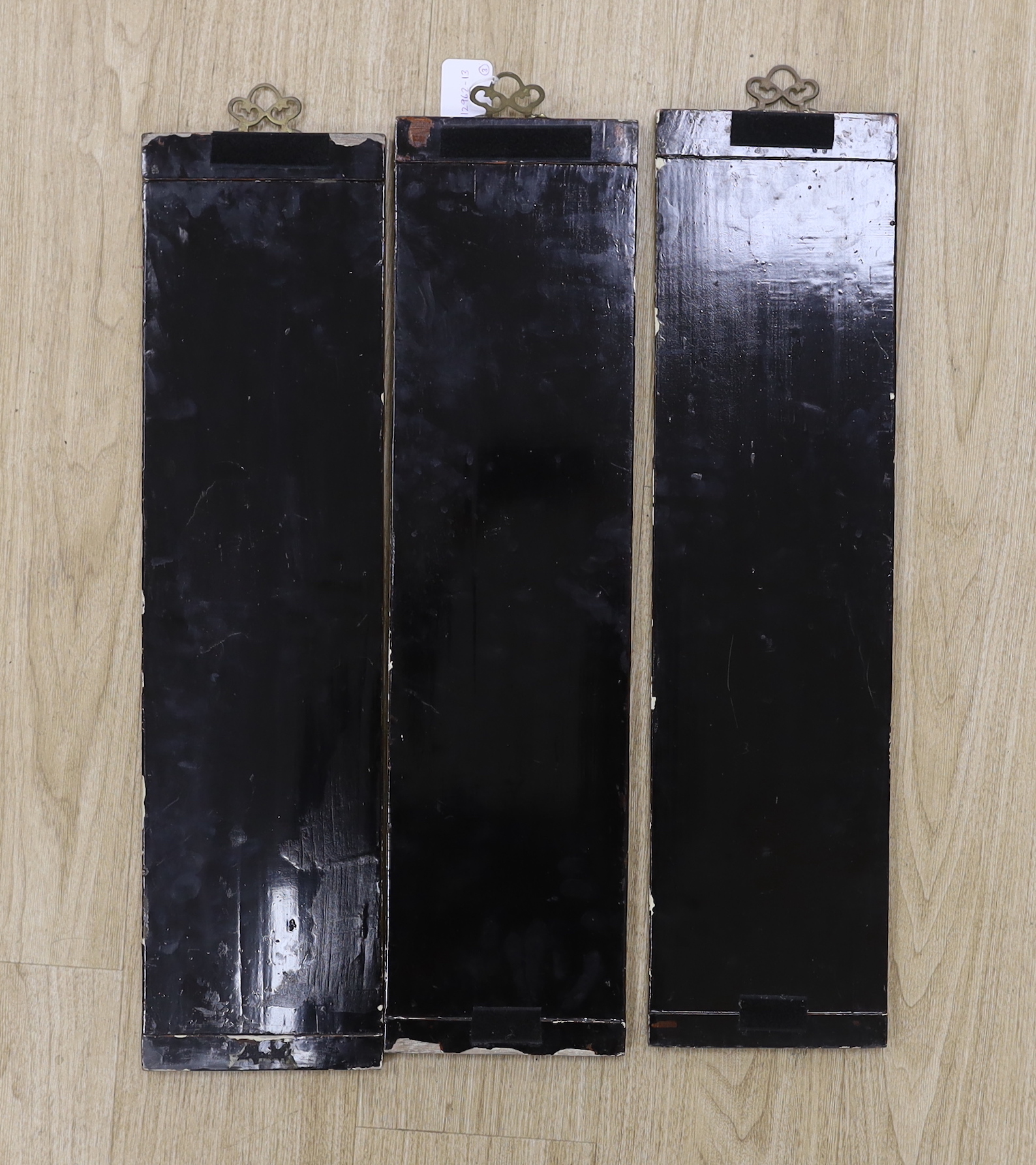 Three Chinese wood lacquered panels of domestic scenes, each 69 x 18cm